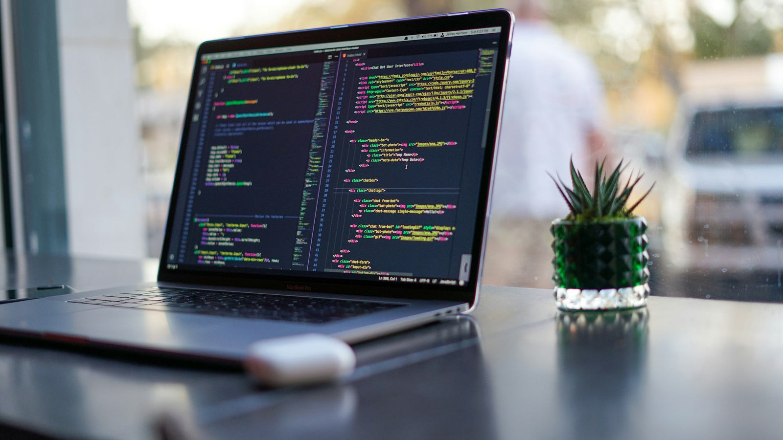 A laptop displaying source code on a café table.