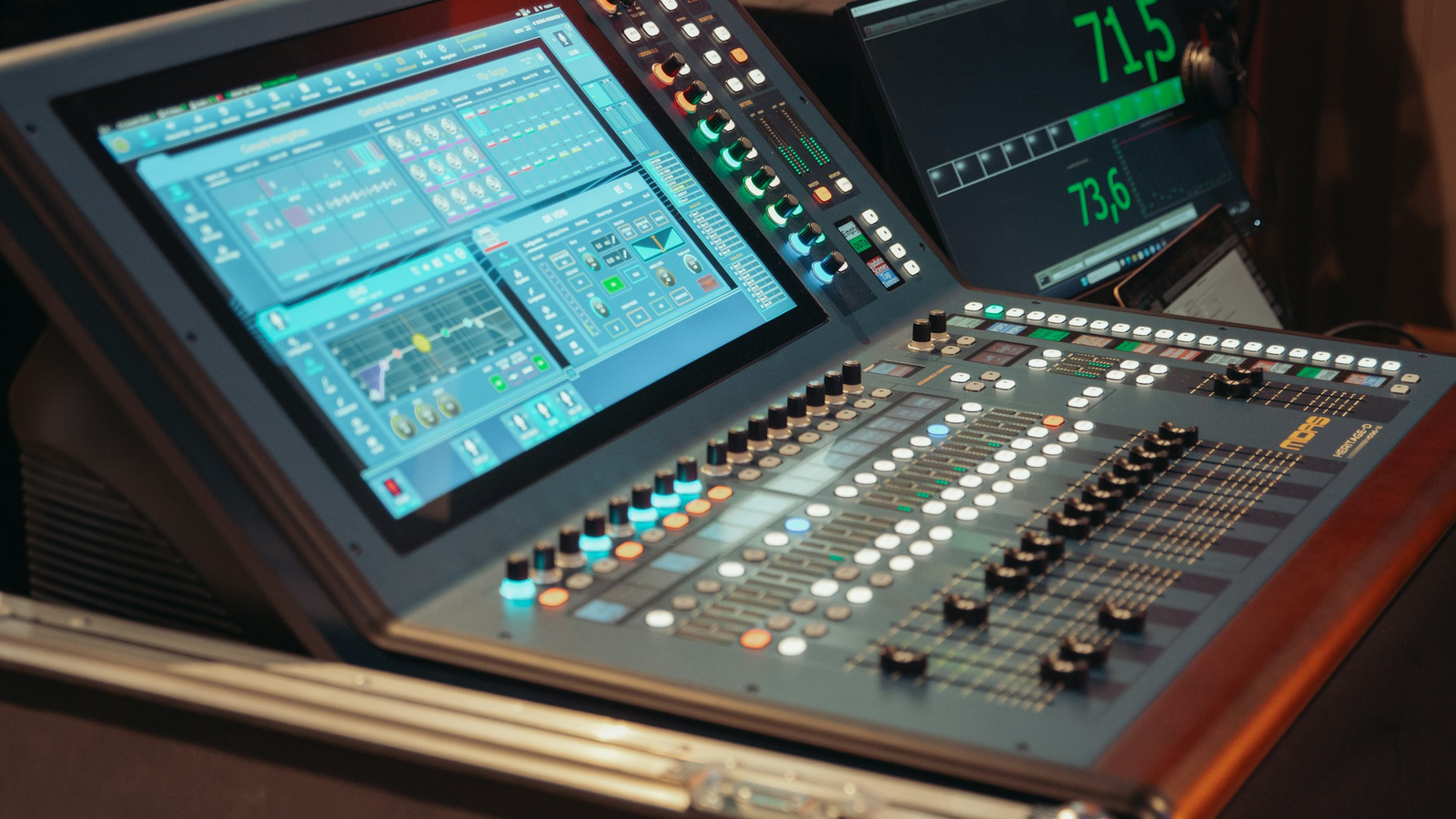 An audio mixing console with repeated faders and controls.