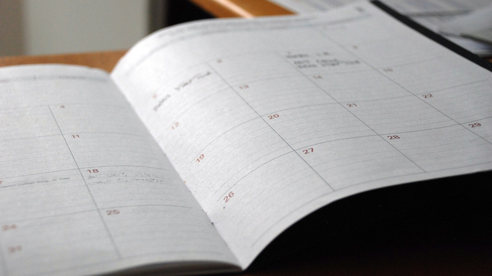 An open monthly planner on a wooden surface.